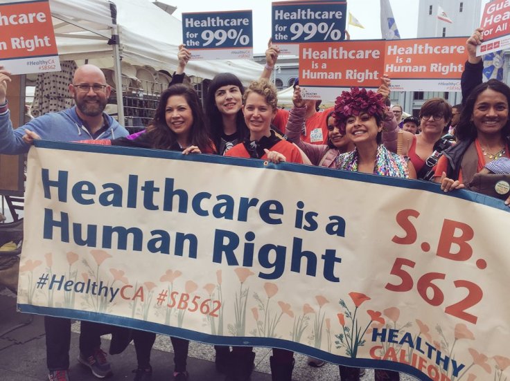 Demonstranten mit einem Transparent auf dem steht, dass die Krankenversorgung ein Menschenrecht ist.